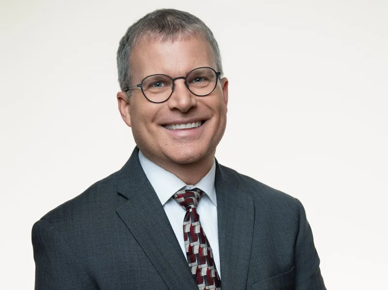 Dean Houdeshell, founder of Innovative Coaching Strategies, in a dark suit and tie